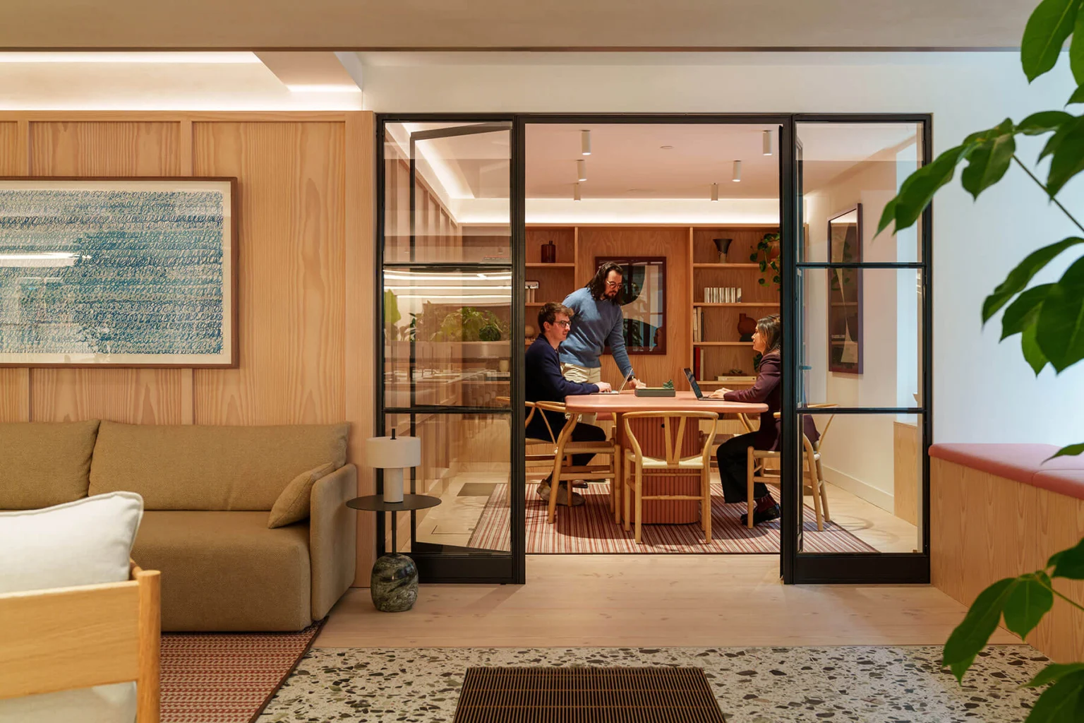 Meeting room behind glazed doors, off a timber-panelled lounge